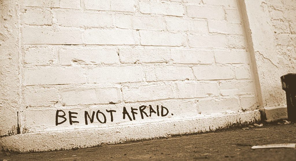 BE NOT AFRAID graffitied on white brick wall